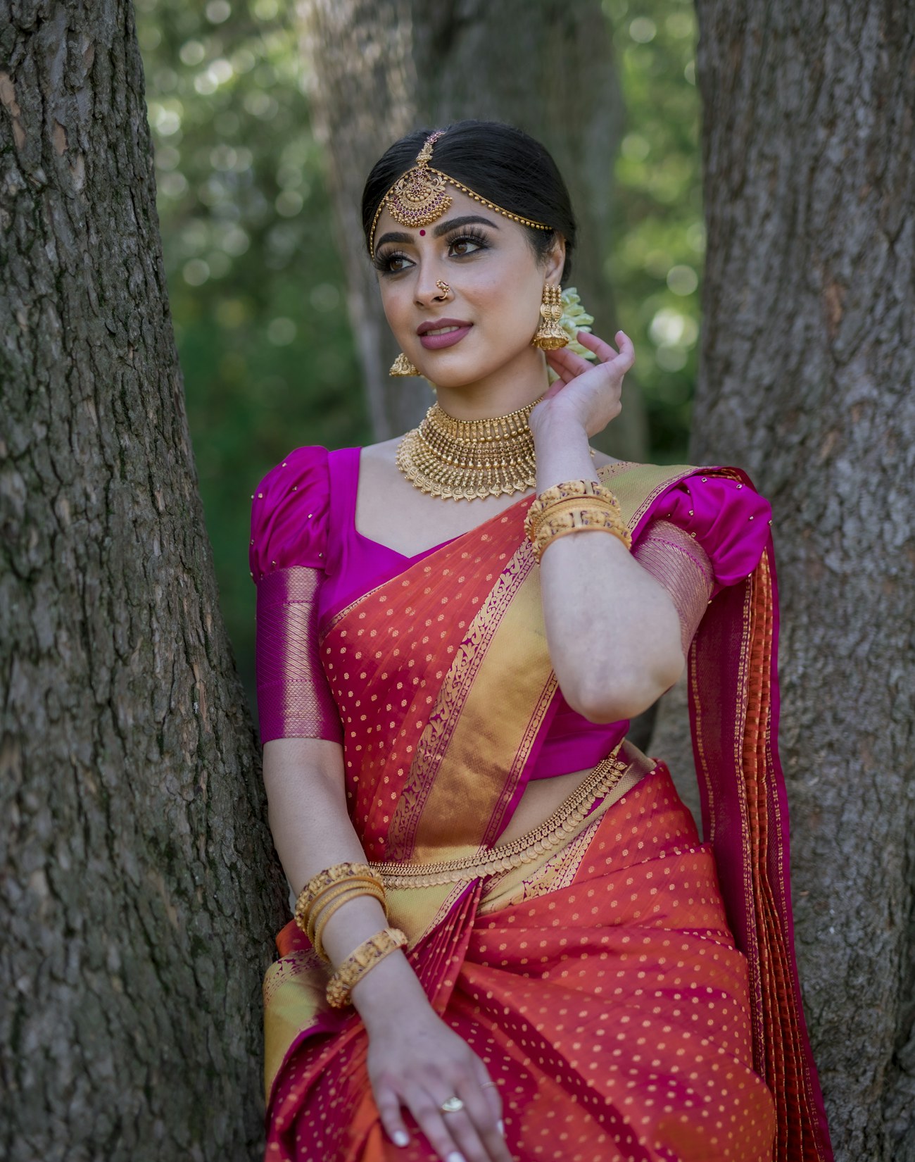 Bride in magenta and gold silk saree outdoors